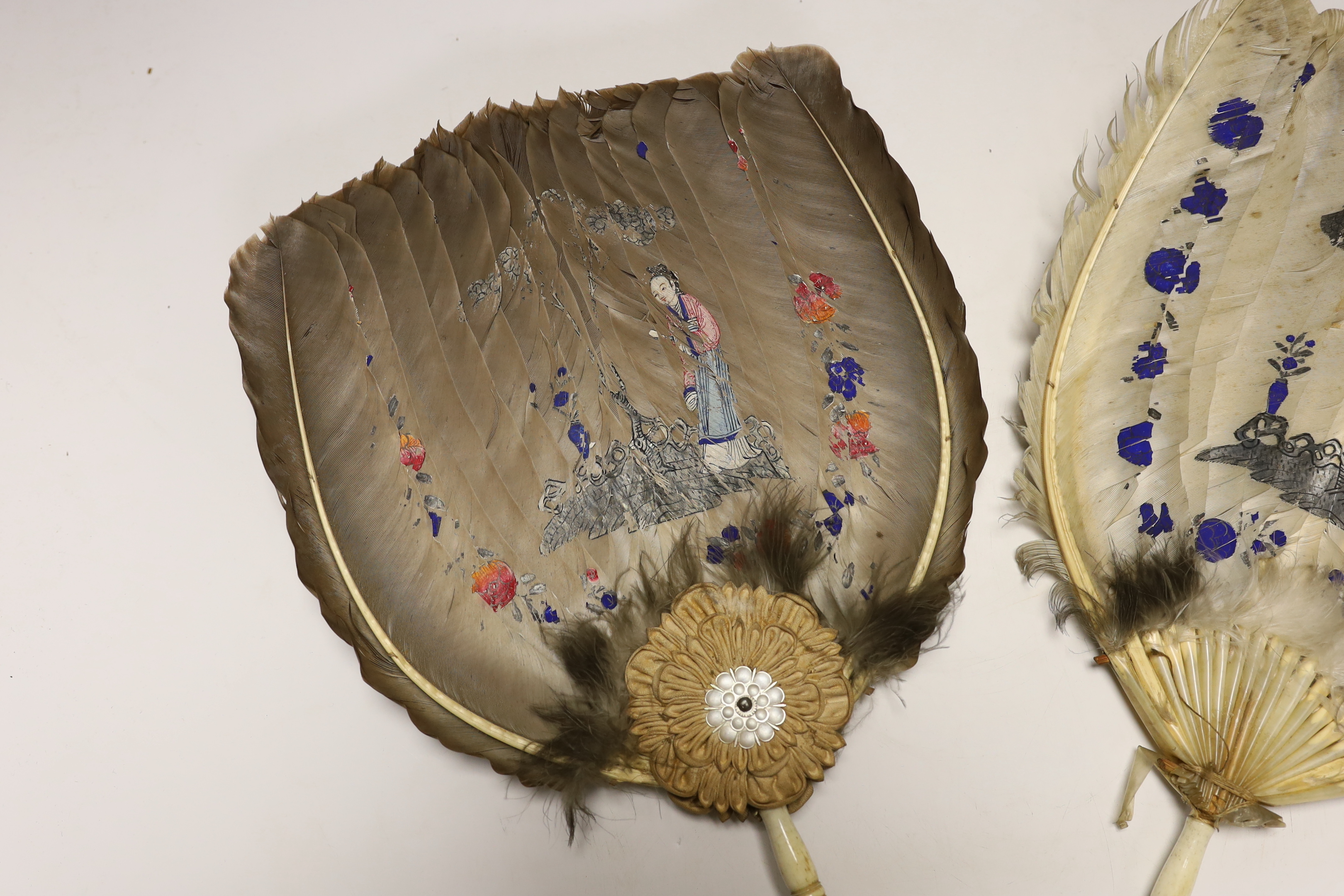 Two feather and bone handled Regency feather fans, the feathers hand painted with Chinese figures one side and flowers the other, one fan has silk rosettes with mother of pearl and feather ornamentation to the top of the